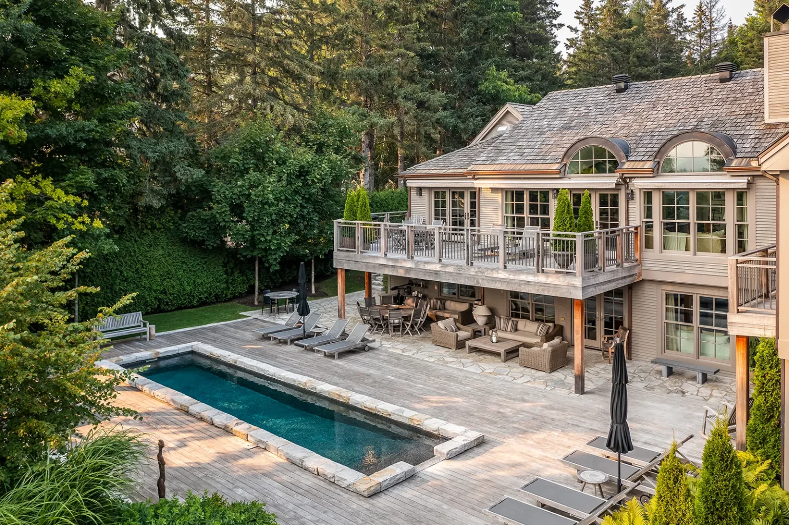 Terrasse en pierre et piscine élégante dans une résidence de Saint-Sauveur