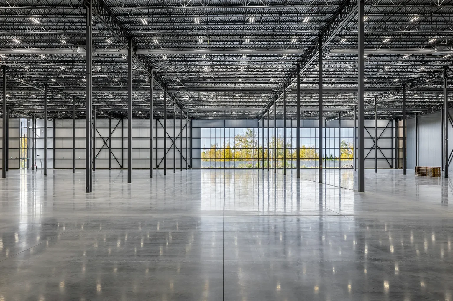 Immense espace d'entrepôt industriel vide baigné de lumière naturelle