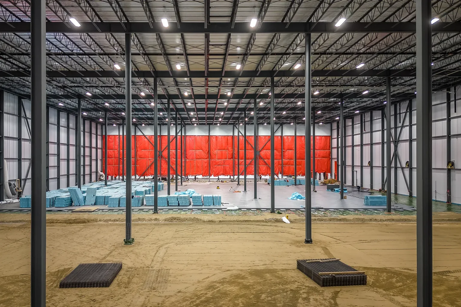 Avancement des travaux à l'intérieur d'un grand entrepôt industriel